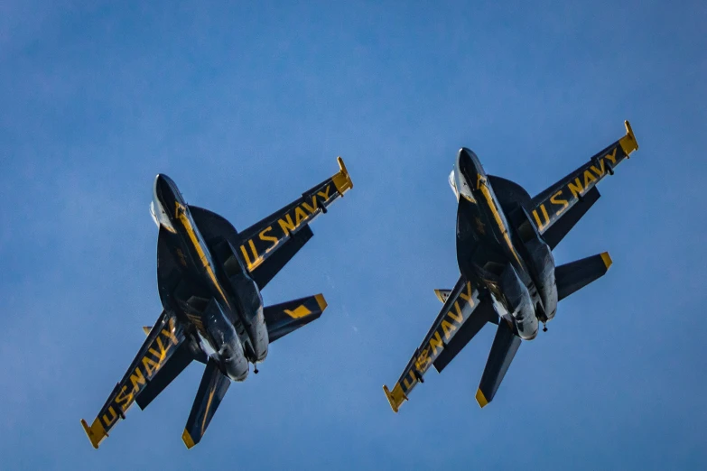 two black and yellow jet planes flying in the air