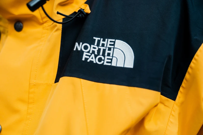 the north face logo is shown on a yellow jacket