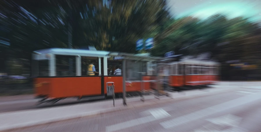 a blurry po of two trolleys traveling down a street