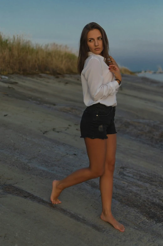 young attractive lady in shorts standing on the beach