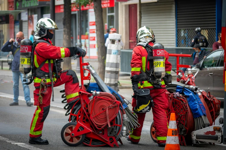 firemen working on equipment and vehicles on a city street