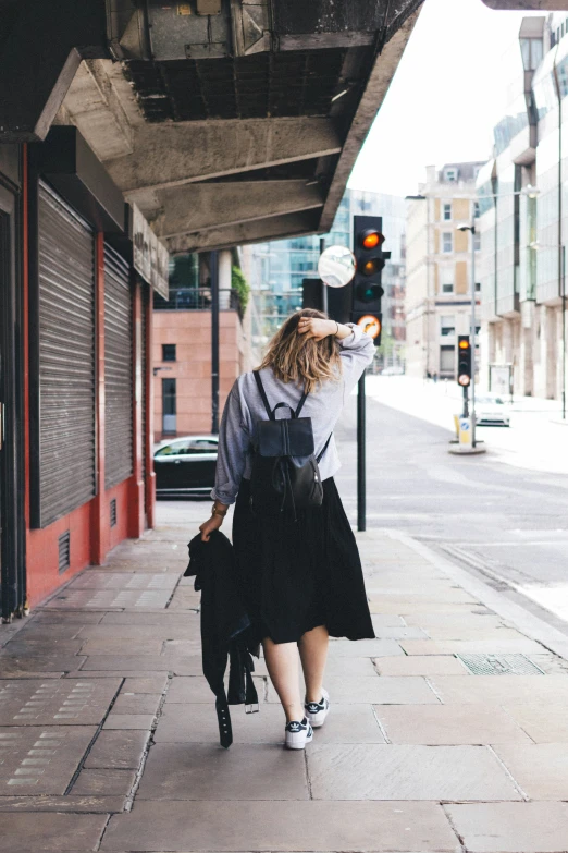 a woman walking down the street wearing an apron