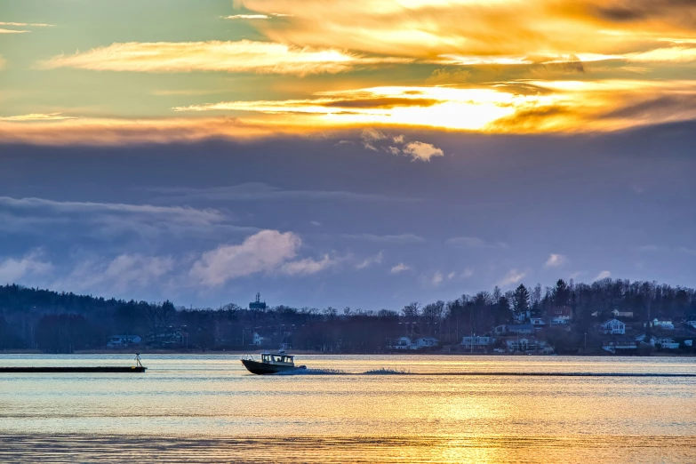 a boat traveling on the ocean at sunset