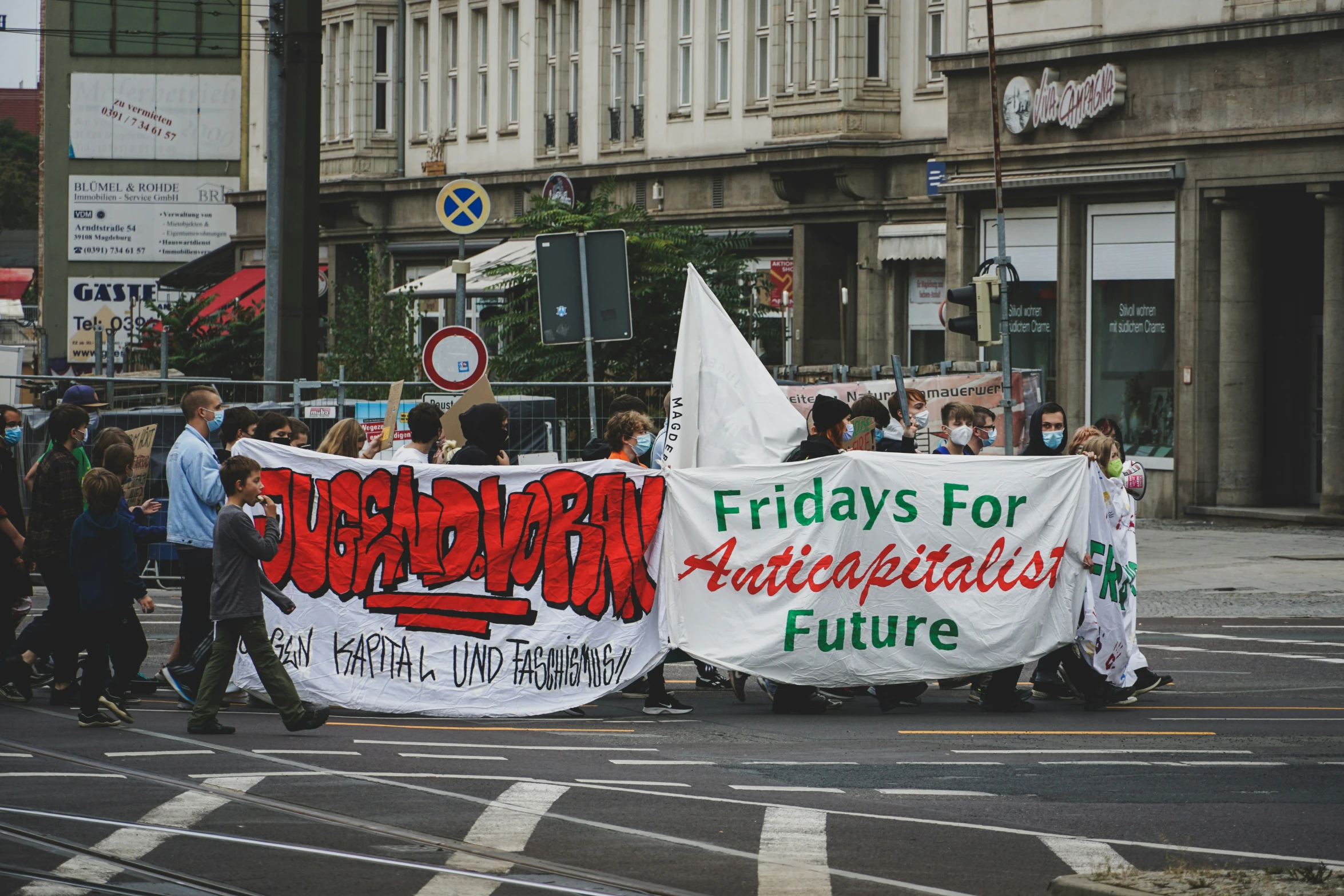 a group of people walking down a street while holding a banner