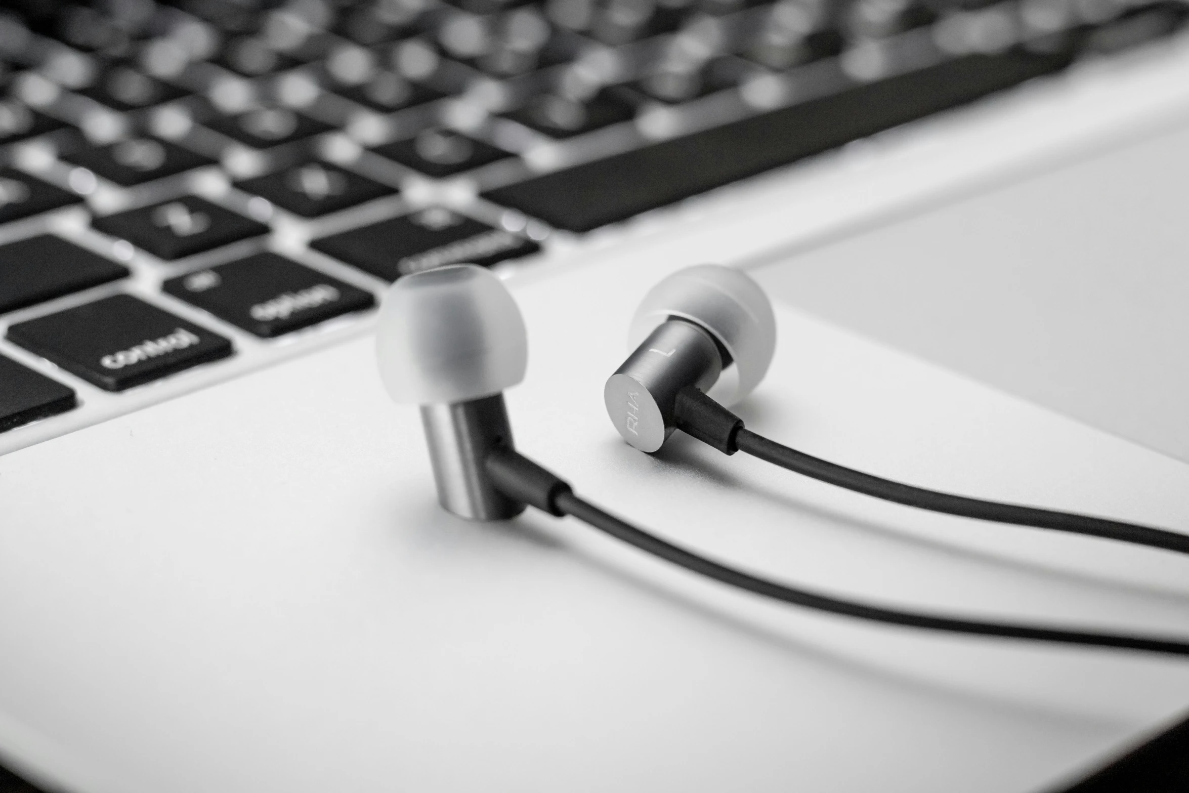 an image of earbud in front of a computer keyboard