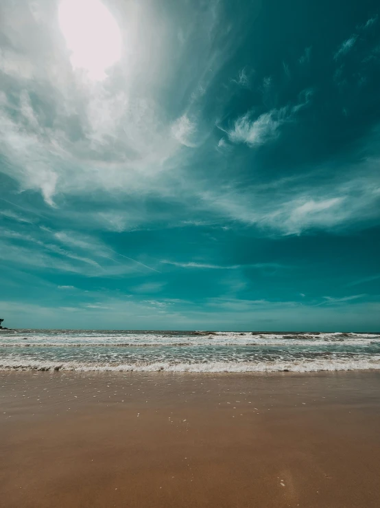 the beach is empty and under the cloudy sky