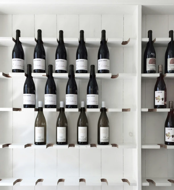 a number of bottles of wine in front of a white wall