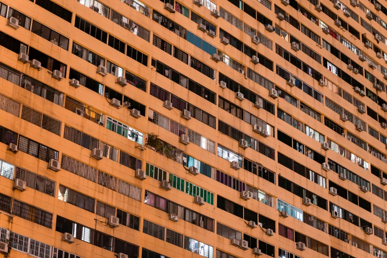 an orange building with rows of window openings and various windows