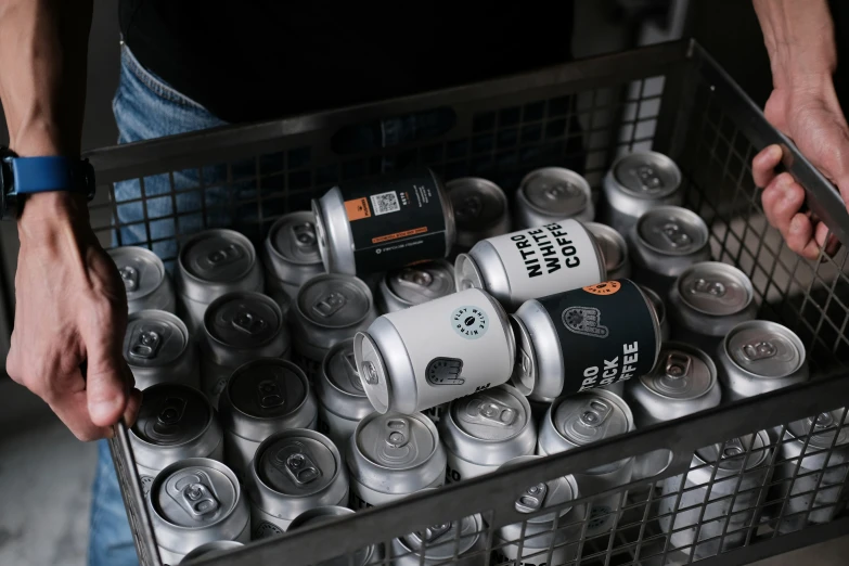 person holding a crate full of metal beer cans