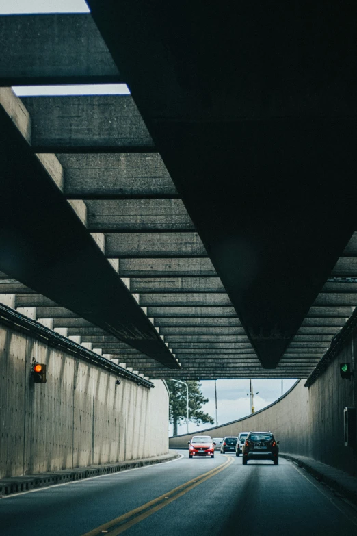 an underpass with three cars driving down it