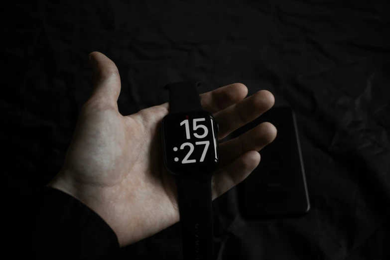 a person holding their phone in their hand and the clock displayed on the watch