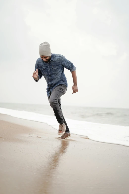 the man is running on the beach in front of the ocean