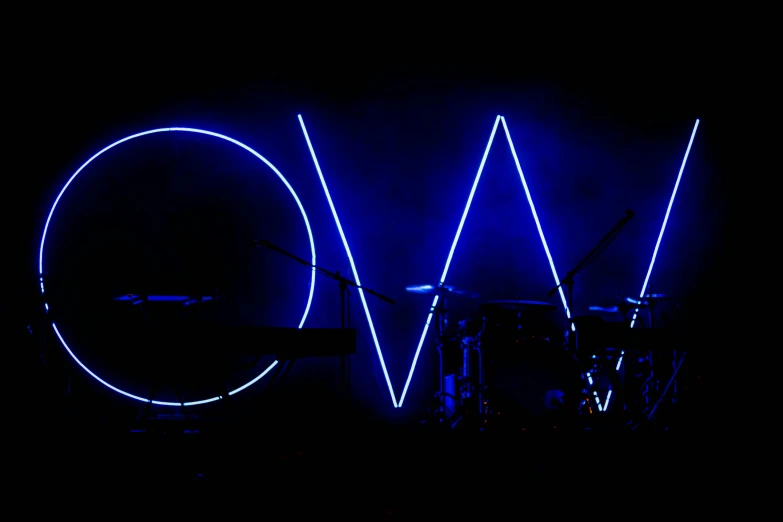a large light sculpture with the word v o in blue on a black background