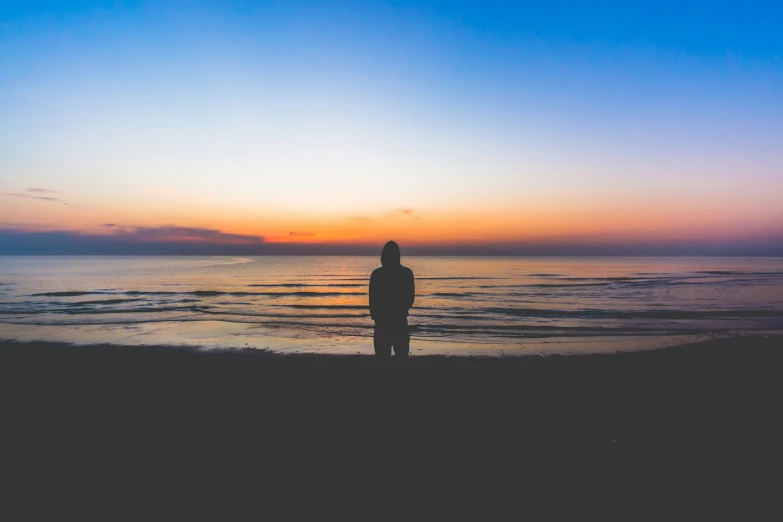 a person standing on a beach near the ocean