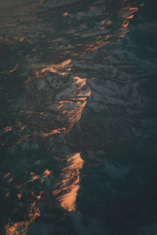 an aerial view of land and water during sunset