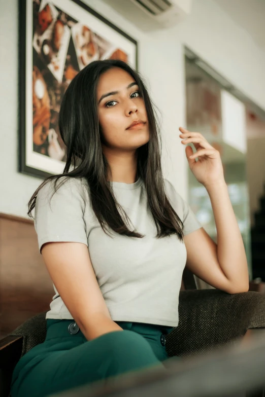 a woman with long black hair sitting in a chair