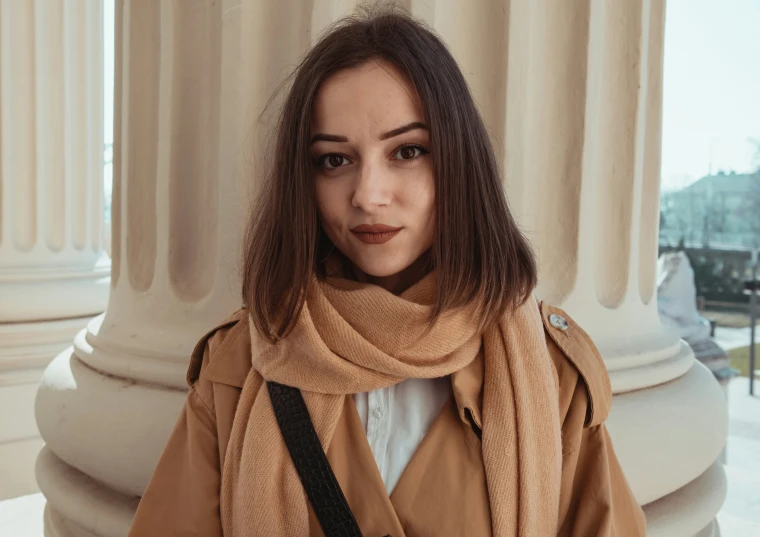 the woman poses for a picture in front of pillars