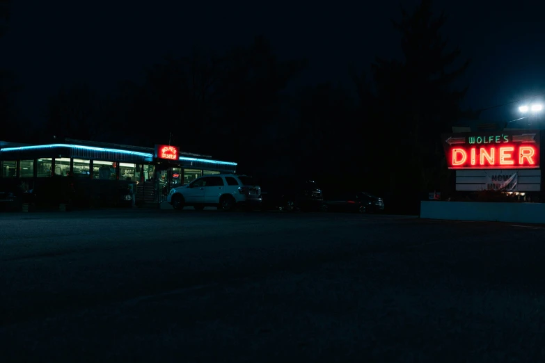 the diner sign is lit up at night, and lit up for dinner