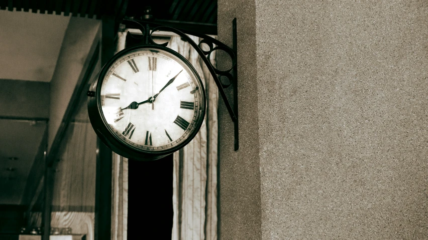 the clock is on a wall outside of a building