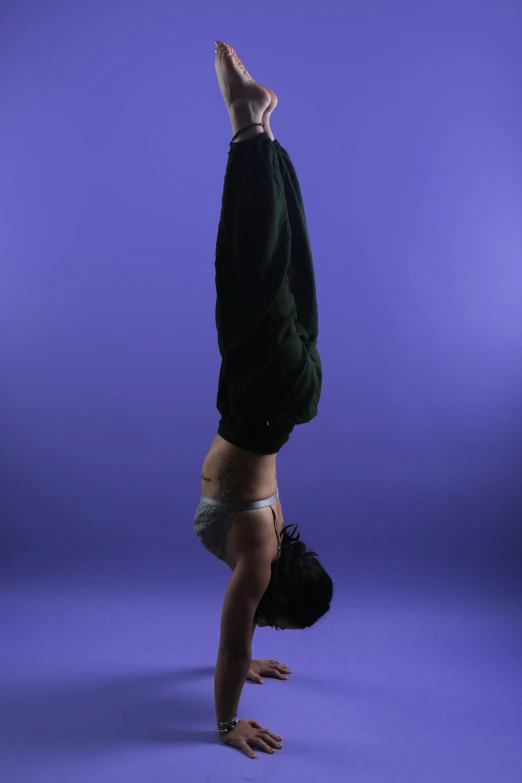 a person doing handstands with their head down on blue background