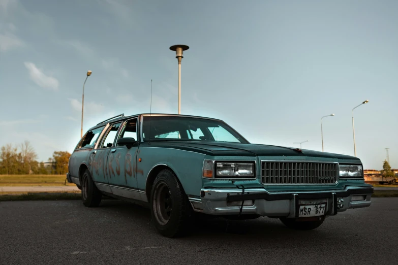 a green station wagon is sitting on the street