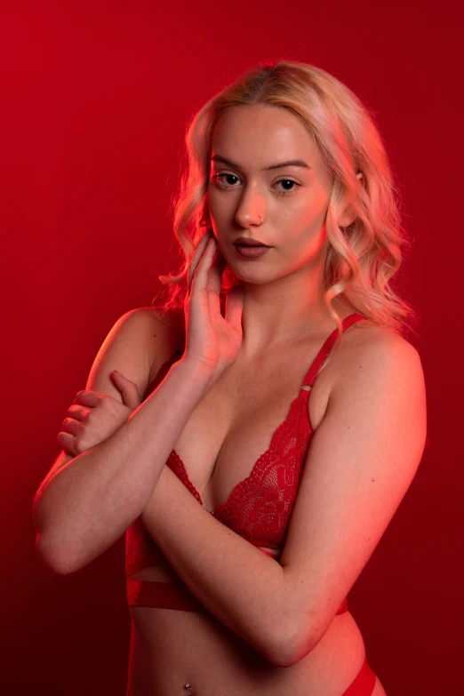 a woman in a red  top standing in front of a red background