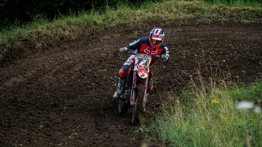 a man on a dirt bike riding through some brush