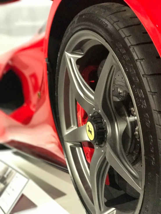 a red ferrari car sitting on top of a floor