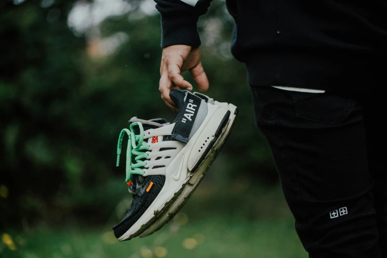 a close - up s of someone holding their white and green air force 1 sneakers