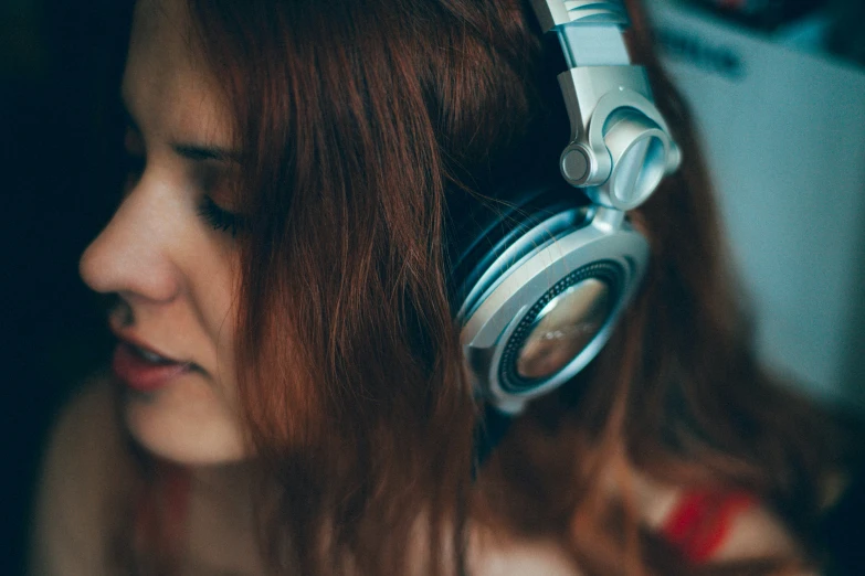 young lady with a concerned look on her face holding onto headphones