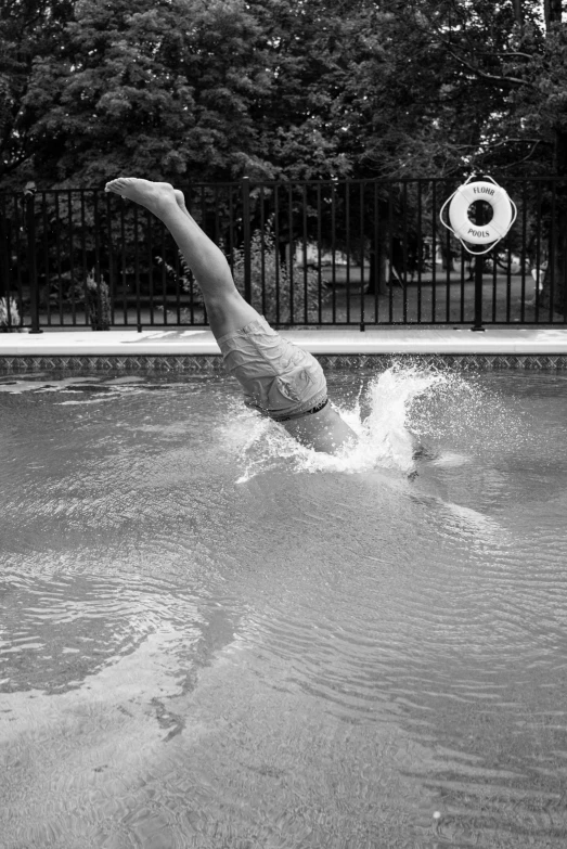 a man falling off his diving board into the water