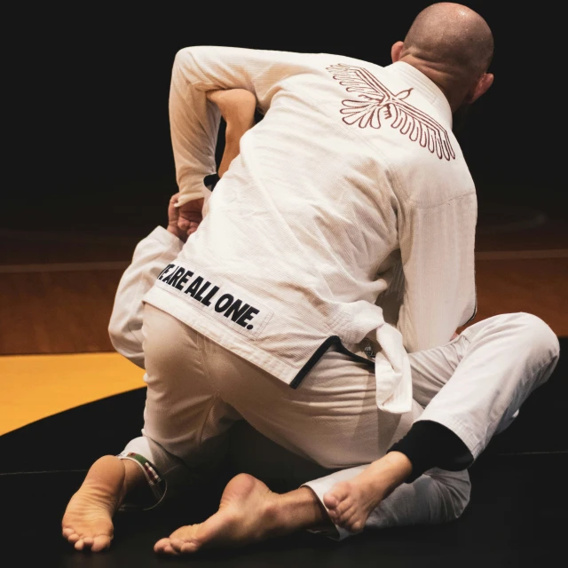 a man sits on a mat while doing a side control trick