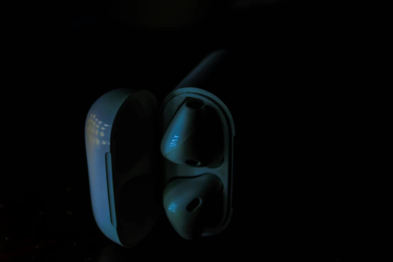 two white ear phones in the dark with lights