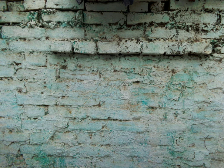 a red fire hydrant sitting next to a dirty wall