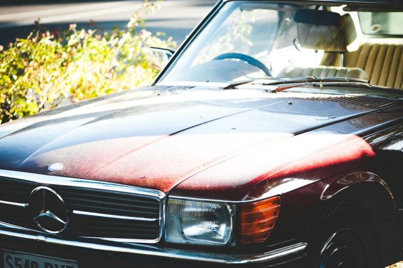 an old mercedes is parked on the side of the road