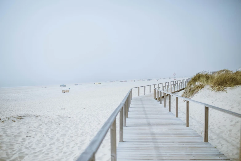 the beach has white sand and boardwalks