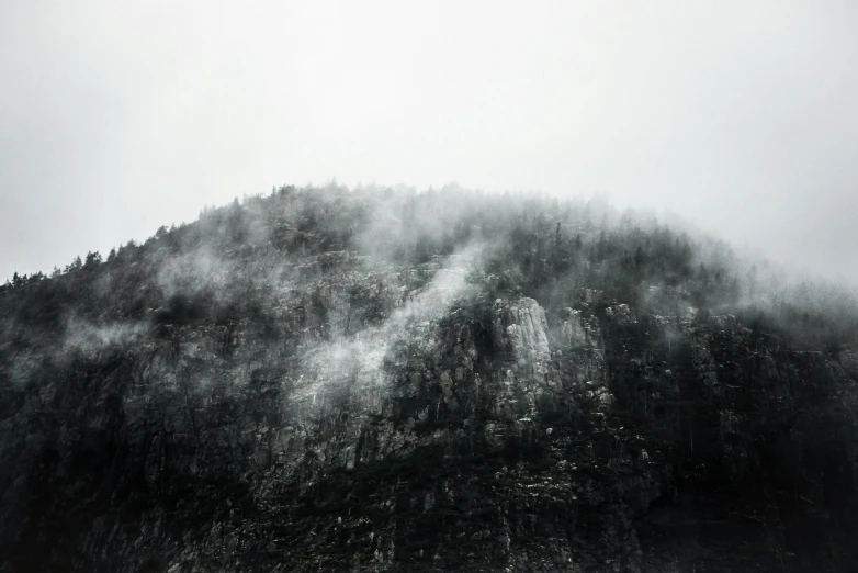 a black and white po of mountains covered in fog