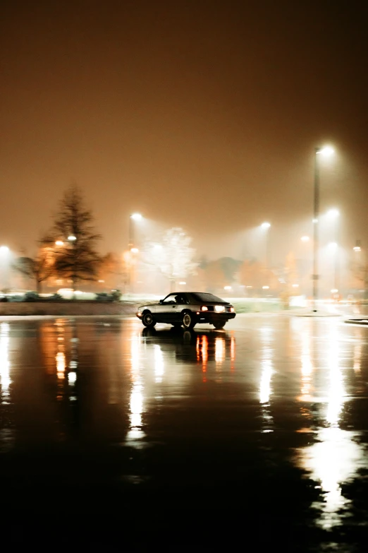 an old car is driving on the road on a rainy night