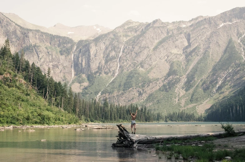 a man in water with a parasail near mountains