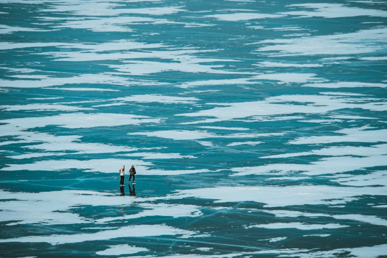 two people standing in an ocean full of water