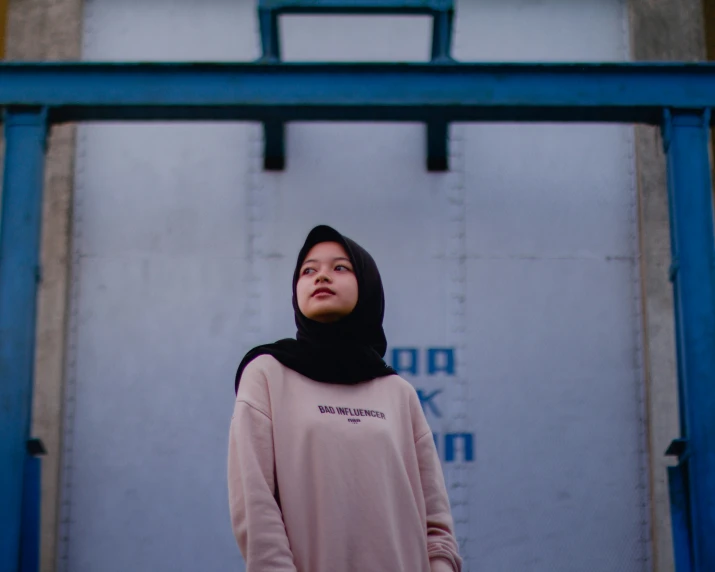 a woman wearing a hijab and wearing a pink top