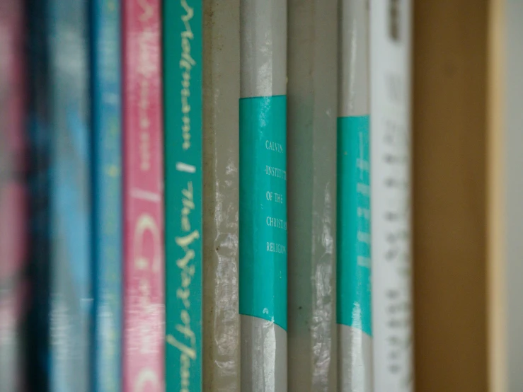 many books sitting on top of each other in a row