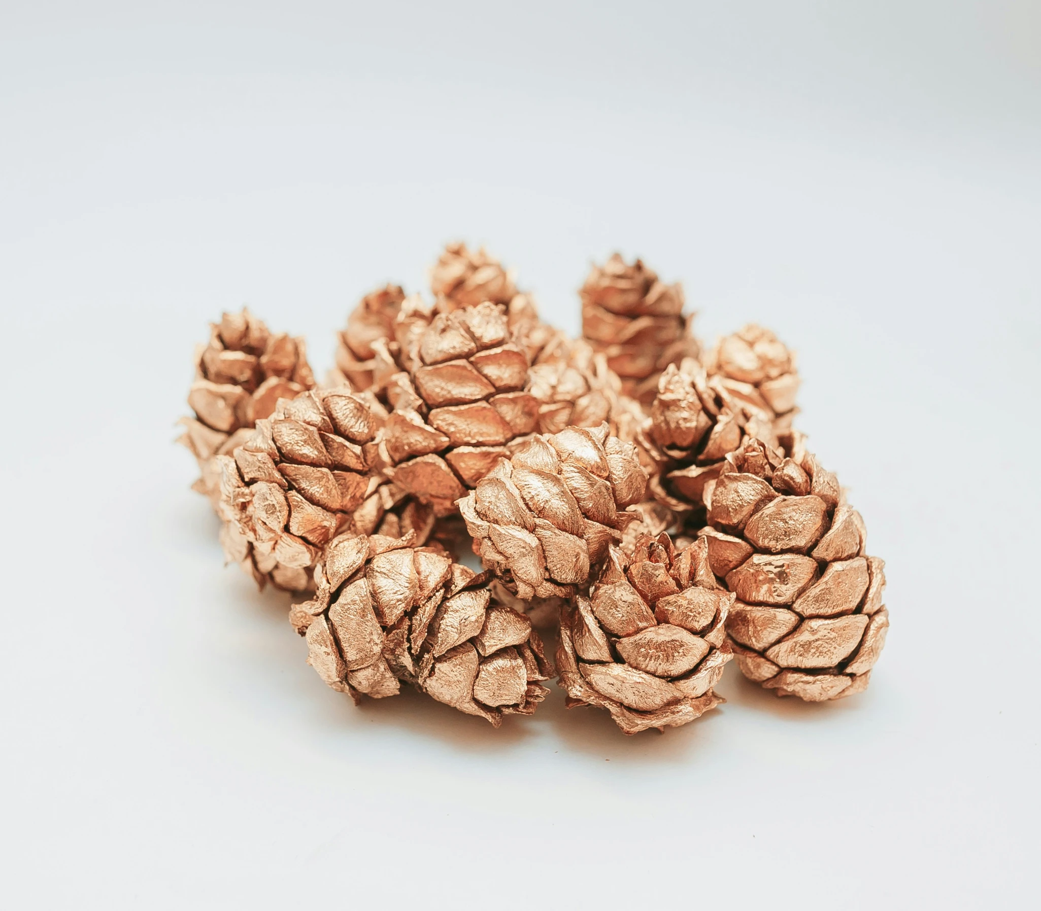 a group of gold pine cones on a white table