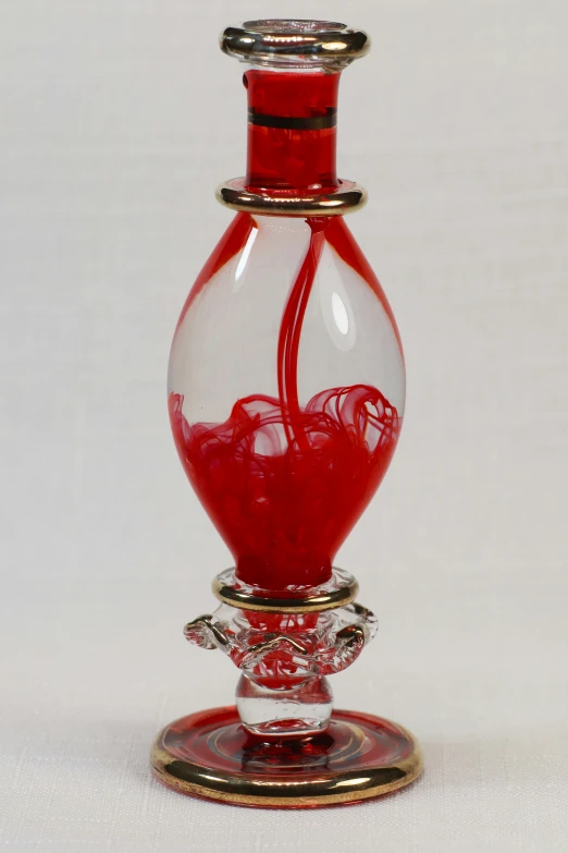 a red vase sitting on top of a glass table