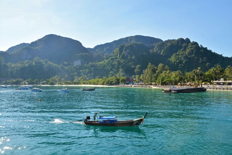 the boat is traveling across the water and is next to the beach