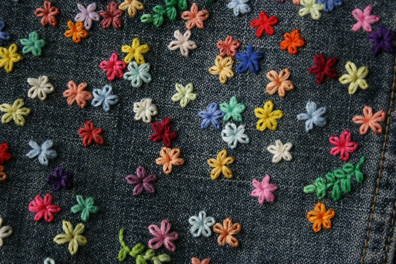 a closeup of colored flower crochet on a pair of jeans