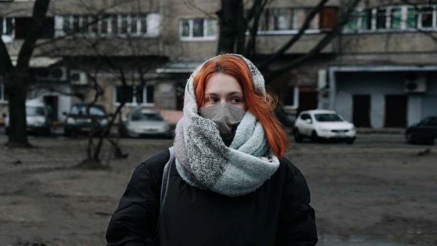a girl with a scarf covering her face