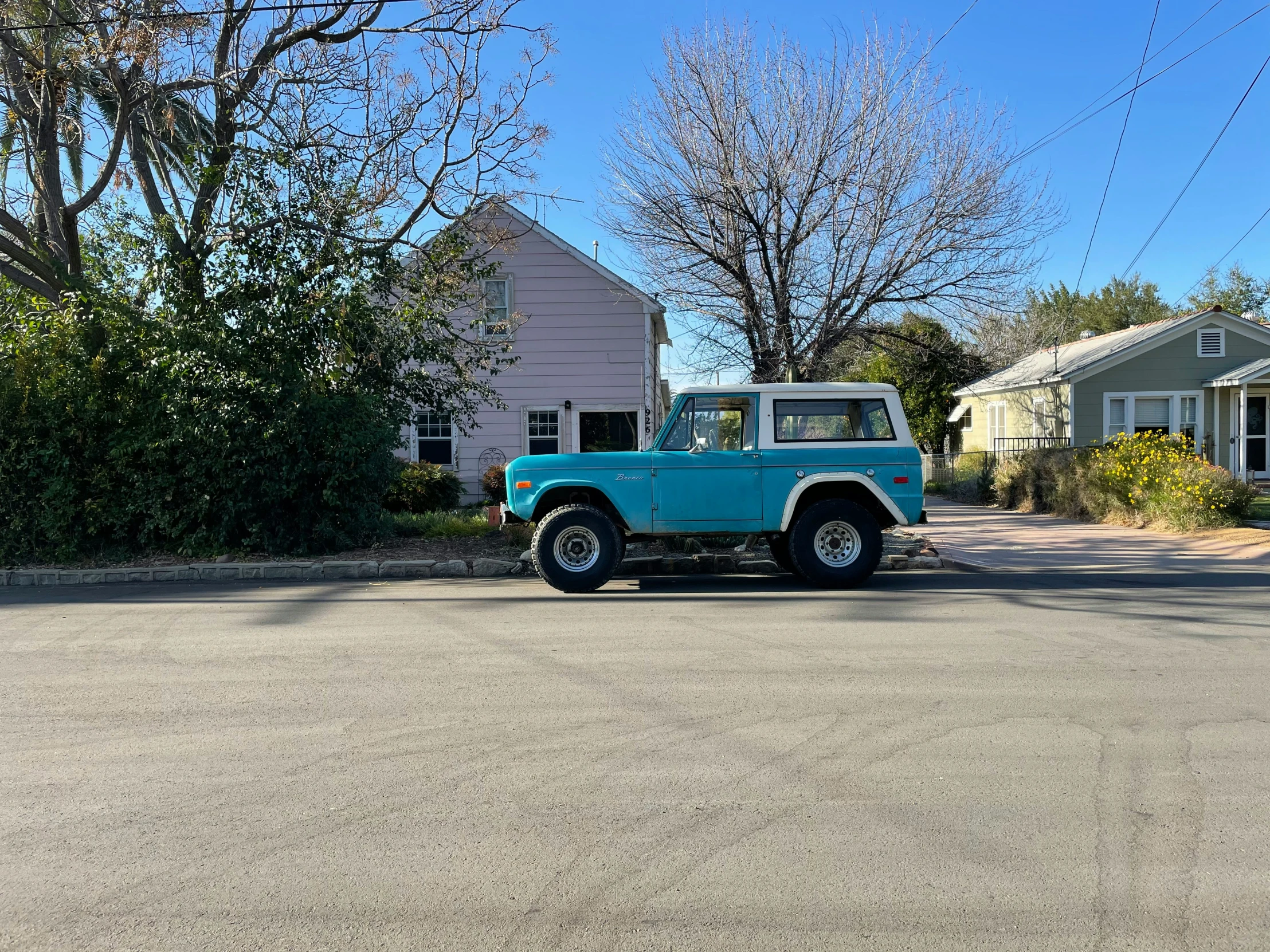 a small blue truck is parked near houses