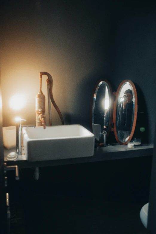 a dark bathroom has a sink and mirror in it