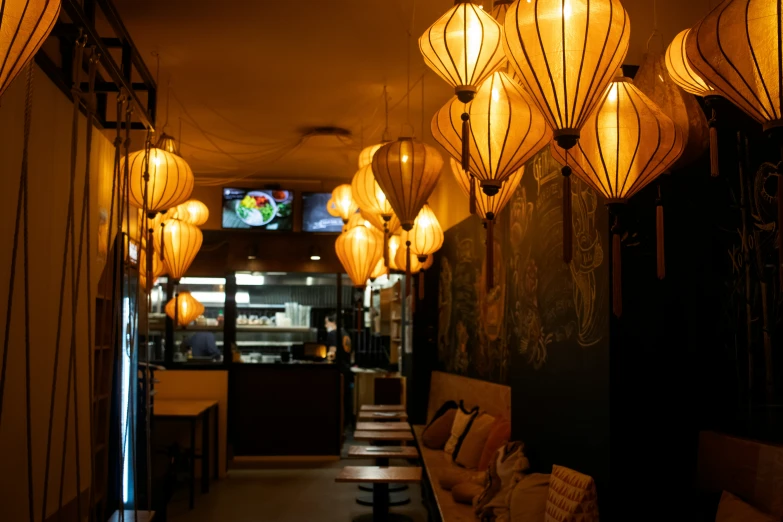 lanterns hang from the ceiling above a row of tables